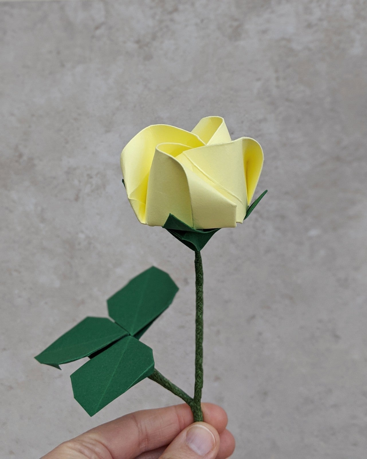 Origami pastel paper rose, single stem flower with leaves