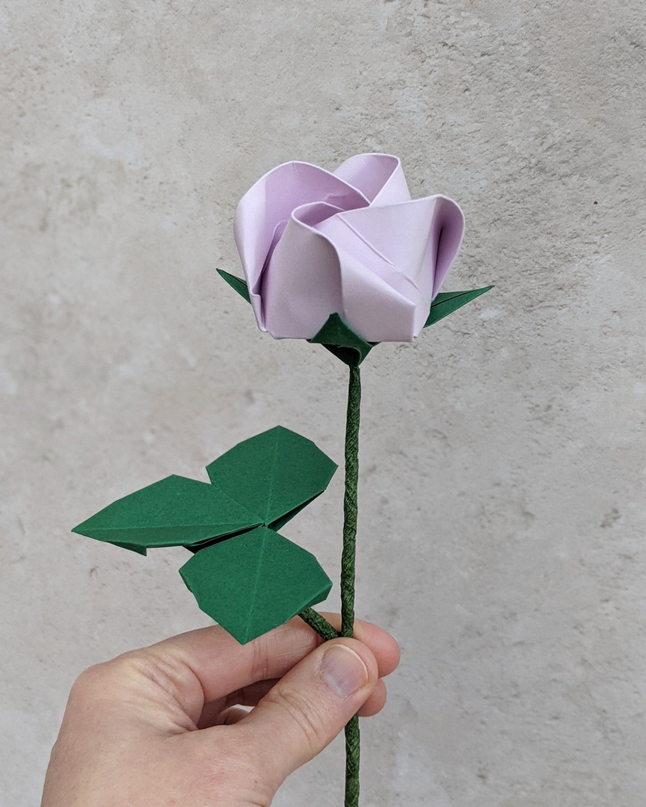 Origami pastel paper rose, single stem flower with leaves