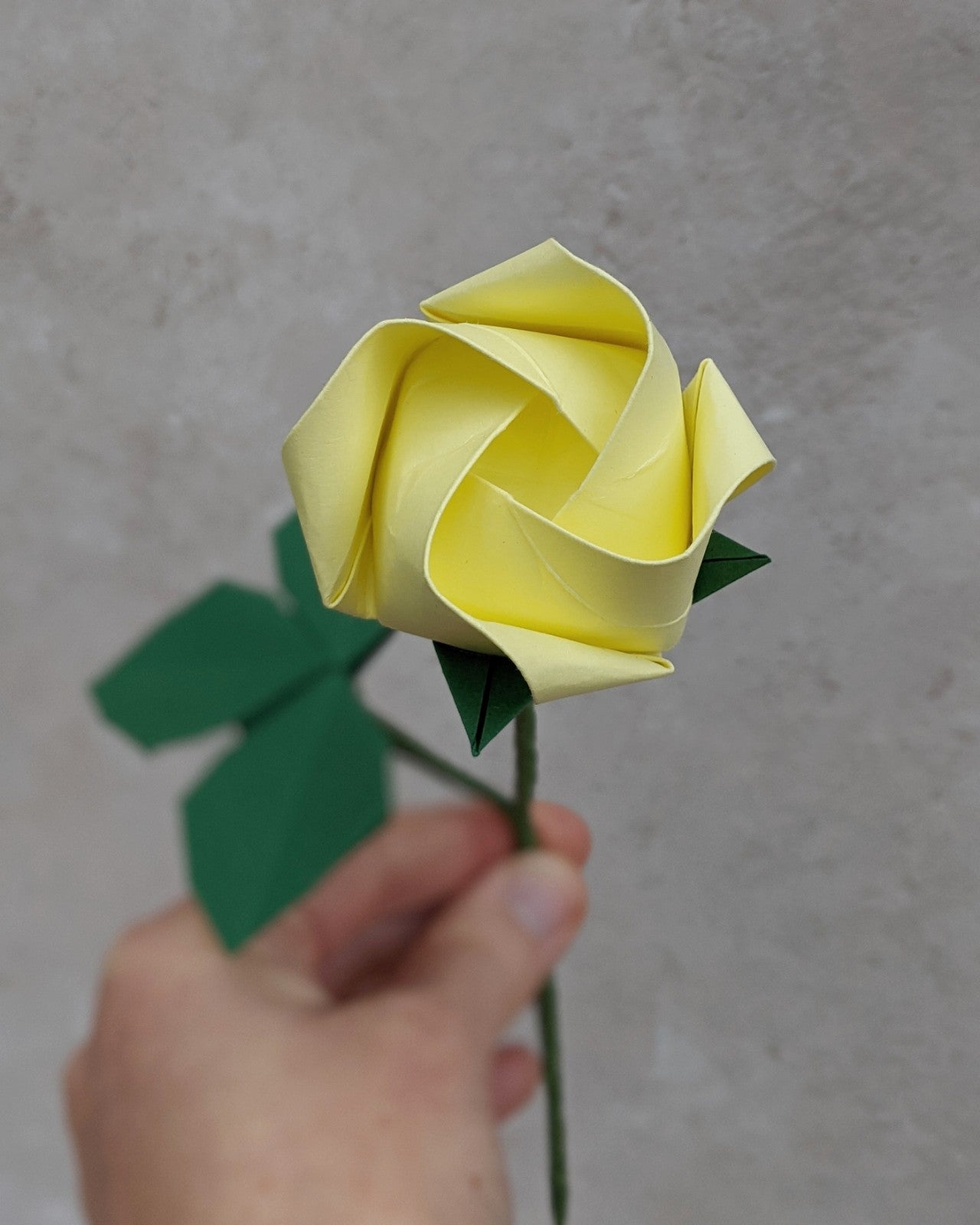 Origami pastel paper rose, single stem flower with leaves