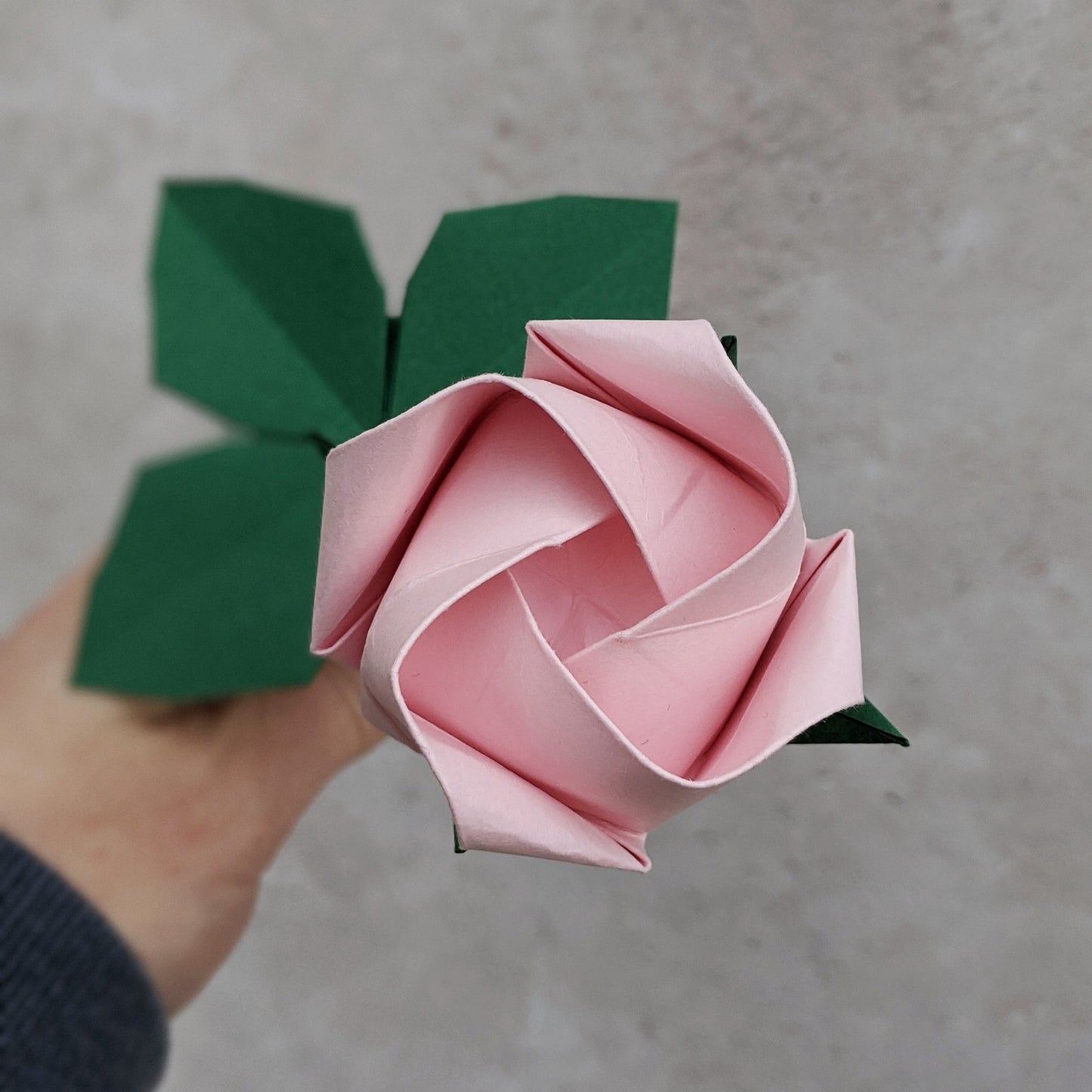 Origami pastel paper rose, single stem flower with leaves