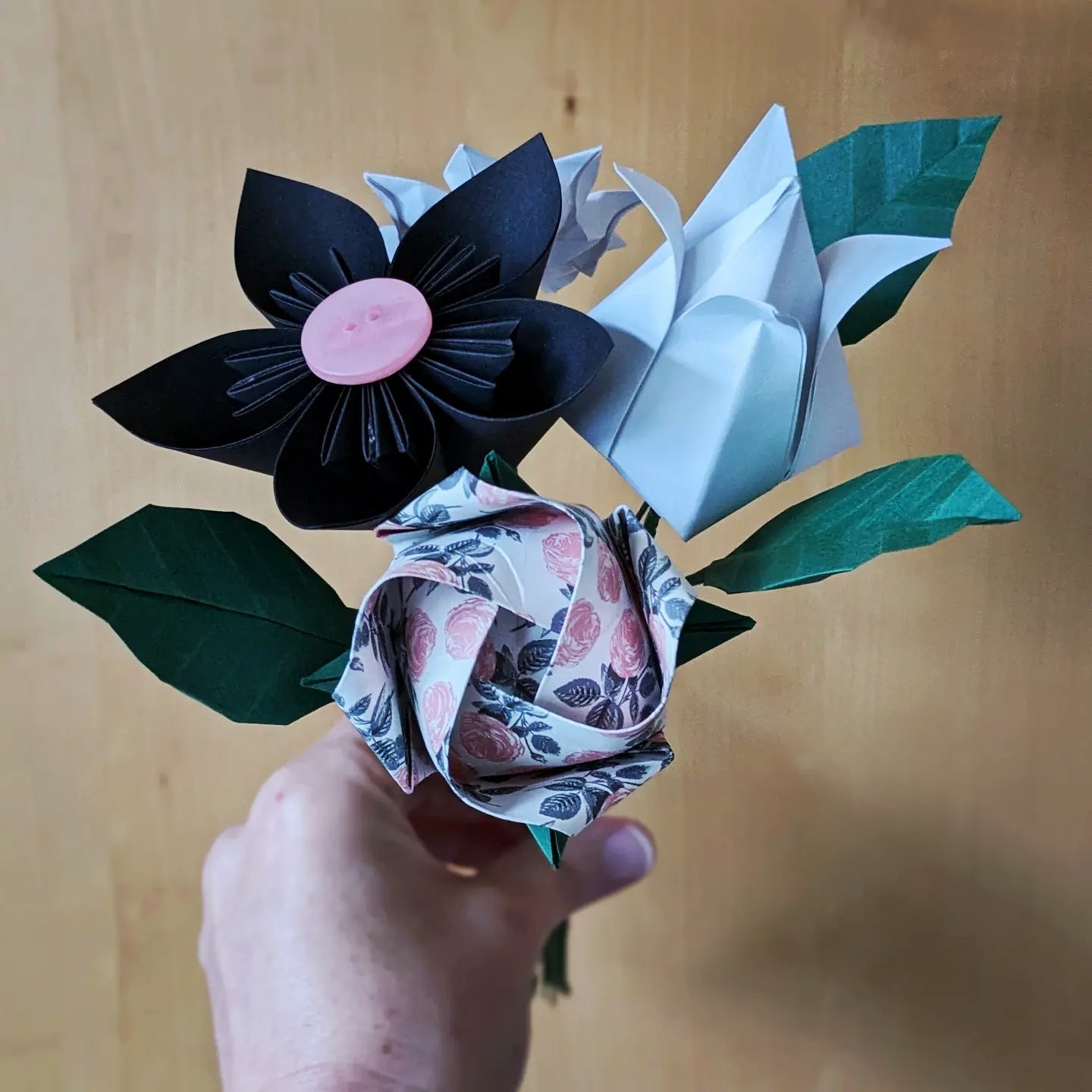 Colourful origami paper flower bouquet with leaves