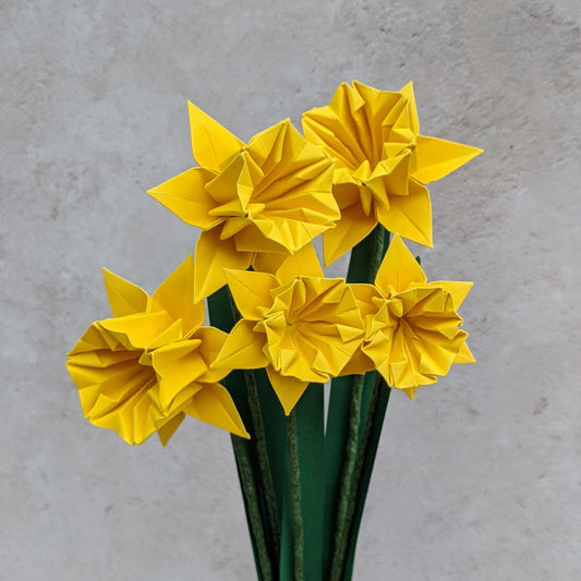 a bouquet of 5 yellow origami paper daffodils with green stems and leaves