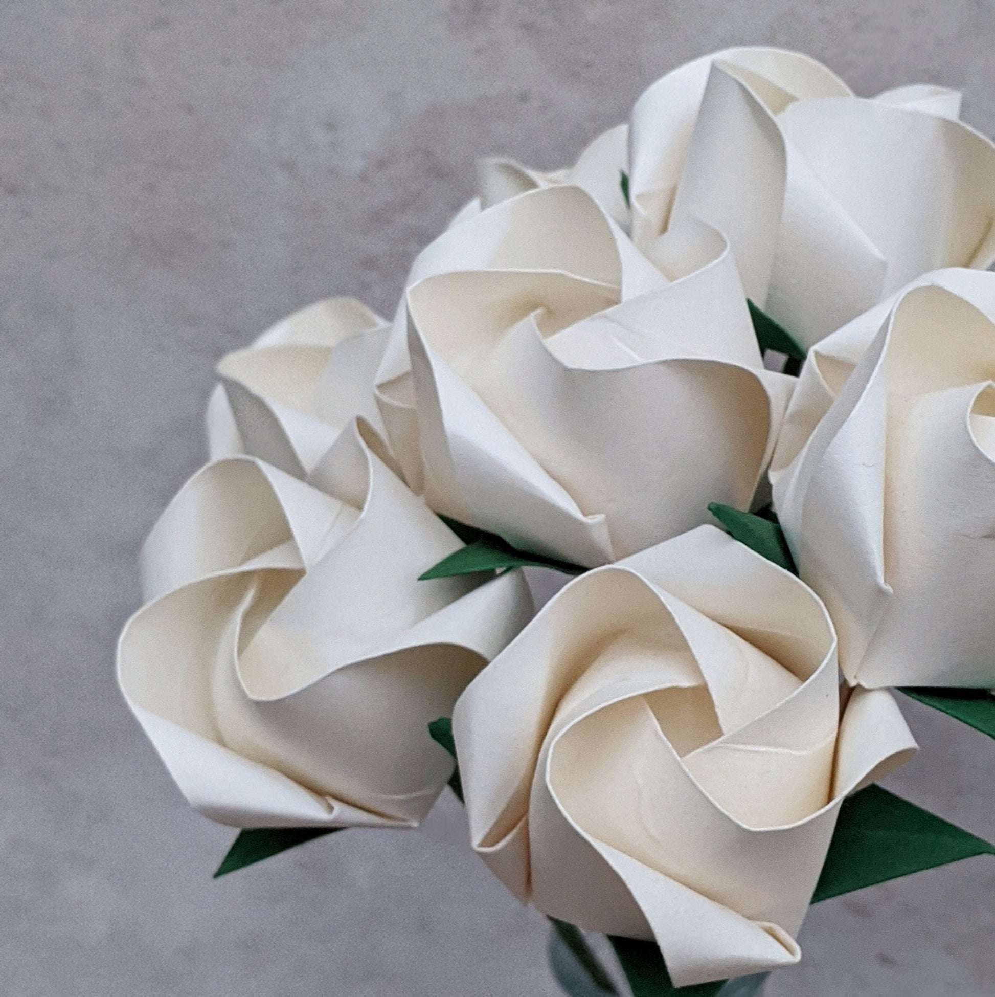 Bouquet of seven ivory origami roses folded from recycled paper 