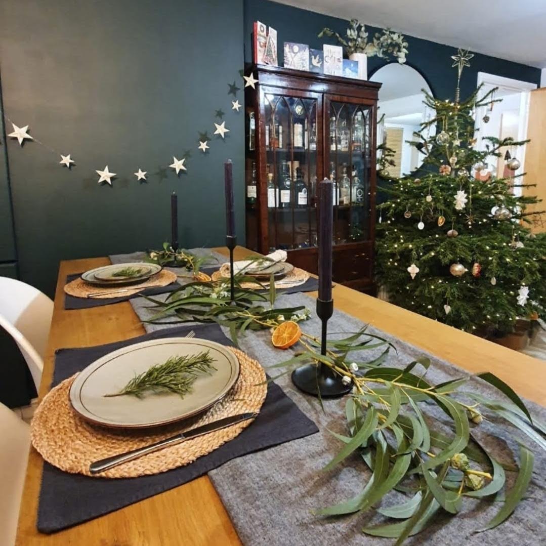 ivory origami star garland hanging across a dark green wall as a christmas decoration