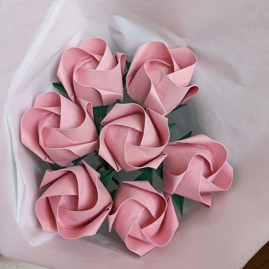 bouquet of seven pastel pink origami roses wrapped in white tissue paper