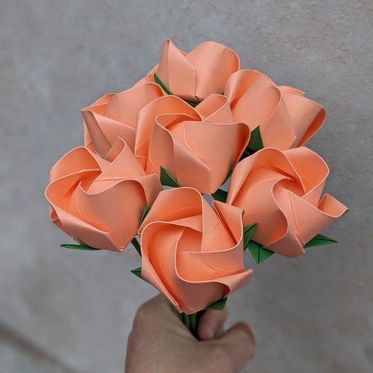 bouquet of seven origami roses folded from peach recycled paper
